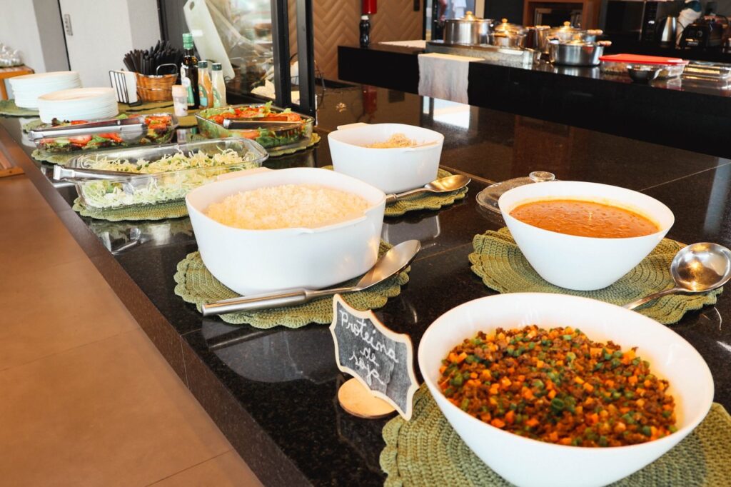 Pista de refeições com saladas e acompanhamentos no Portal Gaia, registrada no Retiro Caminhos da Alma.