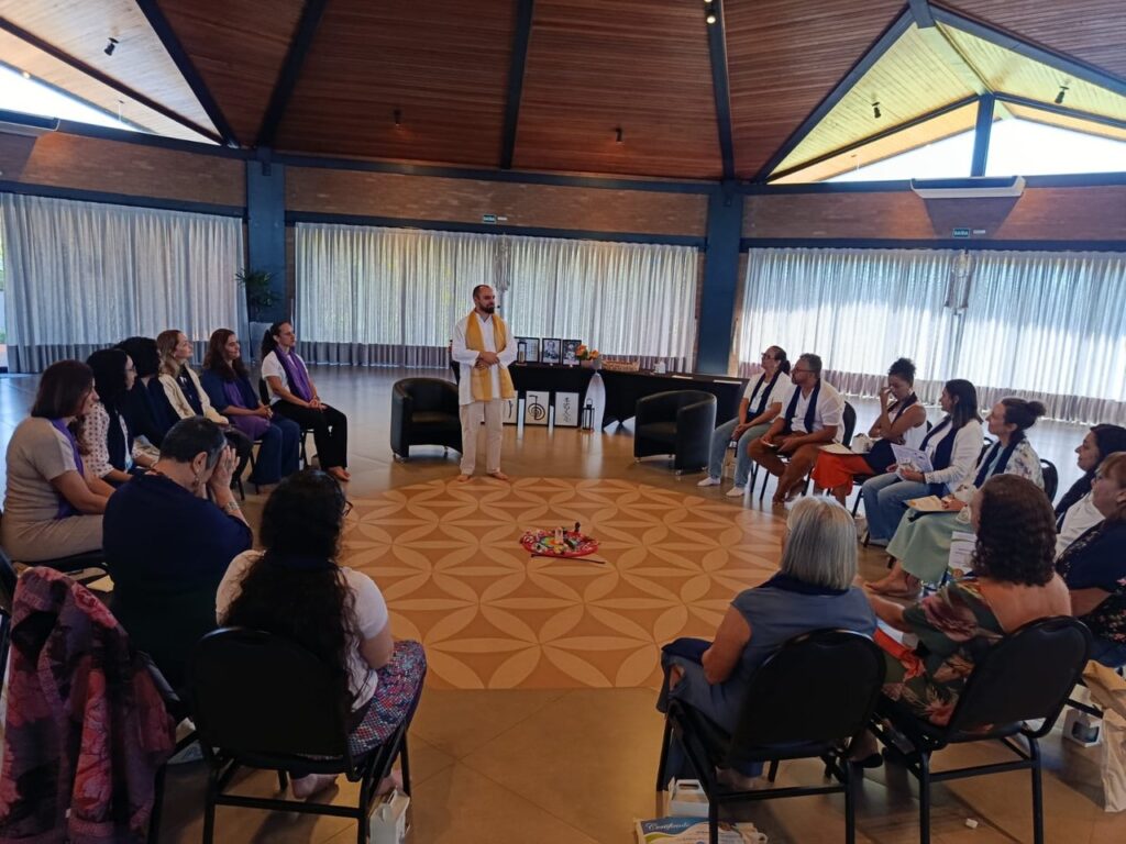 Participantes em roda no salão durante uma atividade do Retiro de Mestres Reiki.